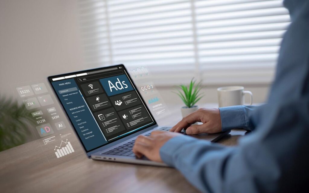 Person managing digital marketing ads dashboard on laptop showing analytics and performance metrics